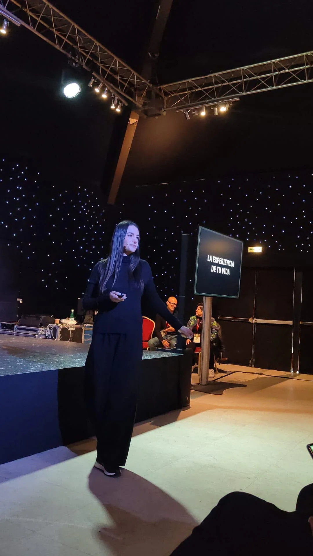 Marlen presenta una charla con micrófono ante el público