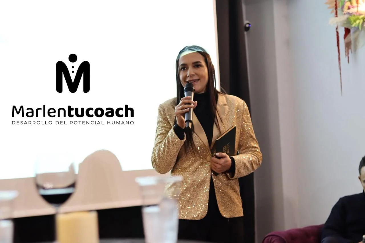 Marlen expone en un evento junto a una pantalla de presentación